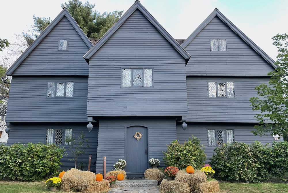 Black house with hay bales and pumpkins 